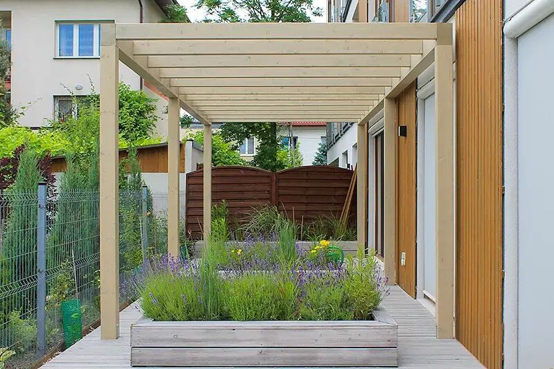 Pergola drewniana przy tarasie domu jednorodzinnego — konstrukcja słupowo-belkowa
